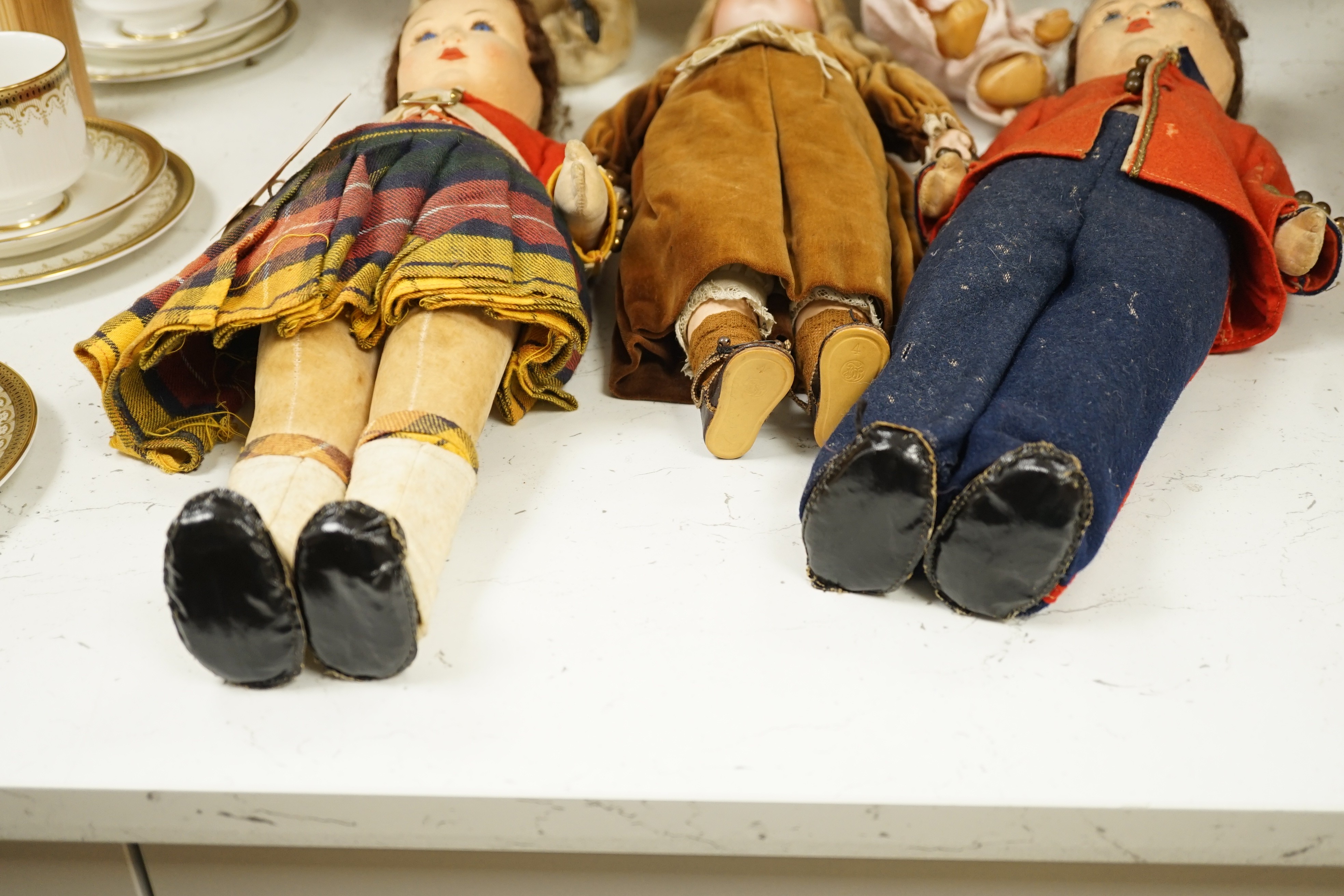 Two Chad Valley felt soldier dolls with glass eyes, a German bisque head doll, a rubber doll and a wind up monkey